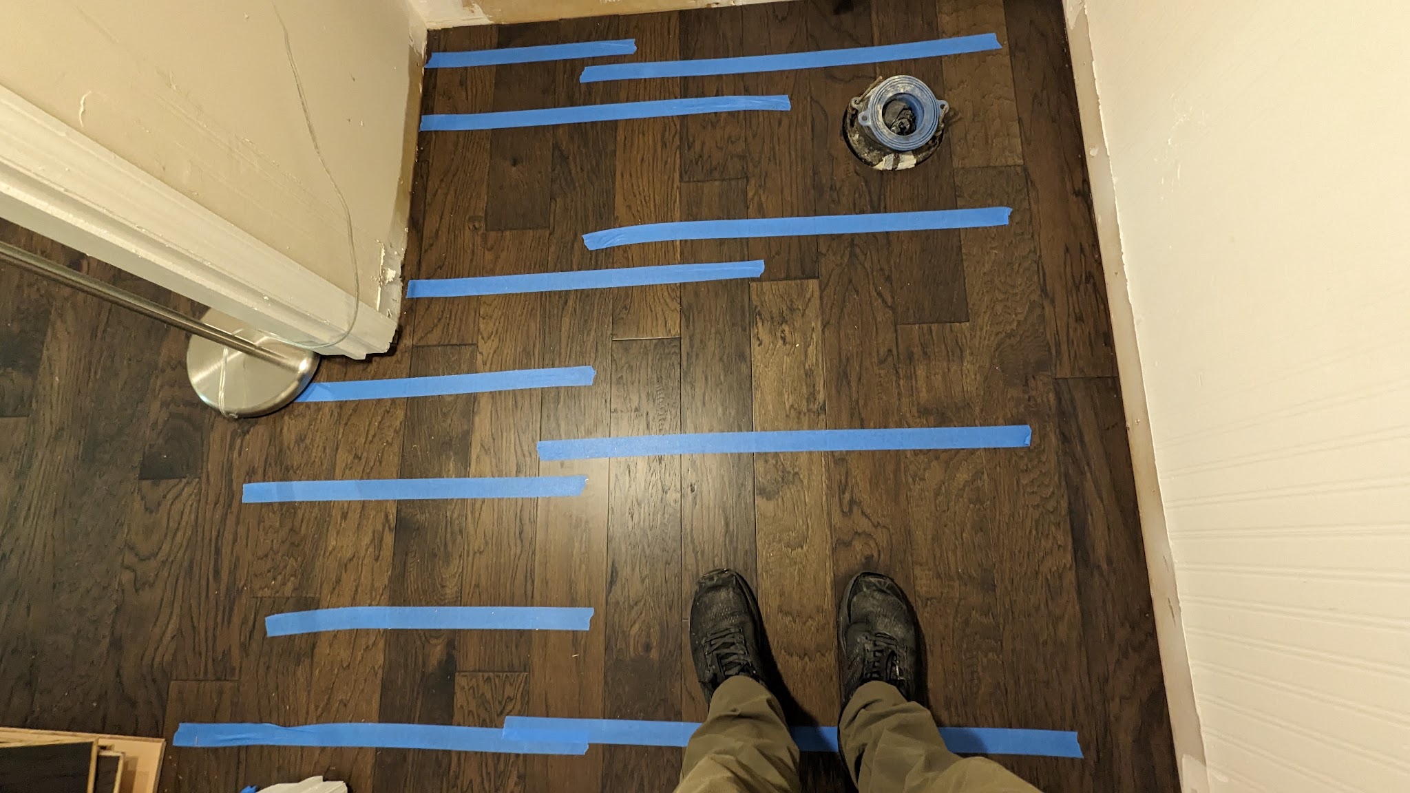 Dark hardwood with layout tape marking the pattern